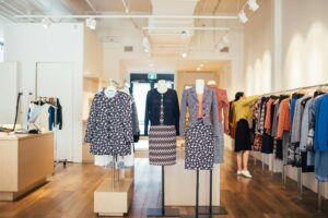 Stylish boutique showcasing colorful and trendy women's apparel on mannequins and racks.